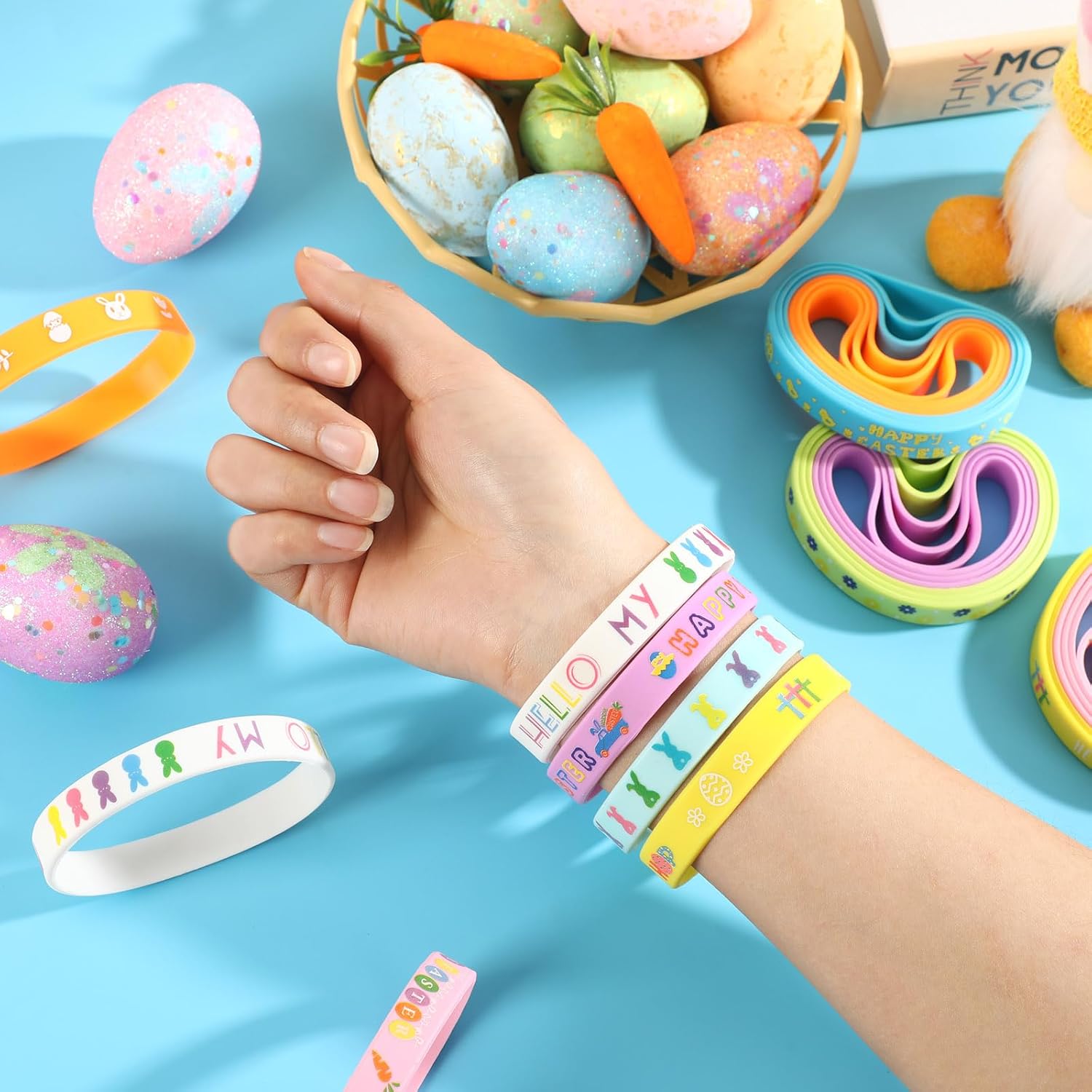 Hand wearing colorful wristbands with Easter eggs and baskets in the background