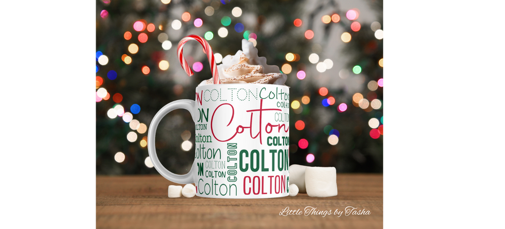 Mug with 'Colton' branding filled with hot chocolate and candy canes against a blurred Christmas lights background.