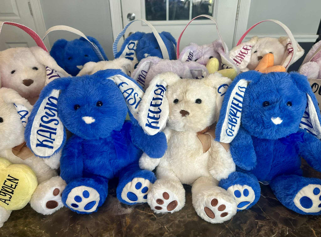 Collection of blue and white stuffed animals with visible brand names on a table.