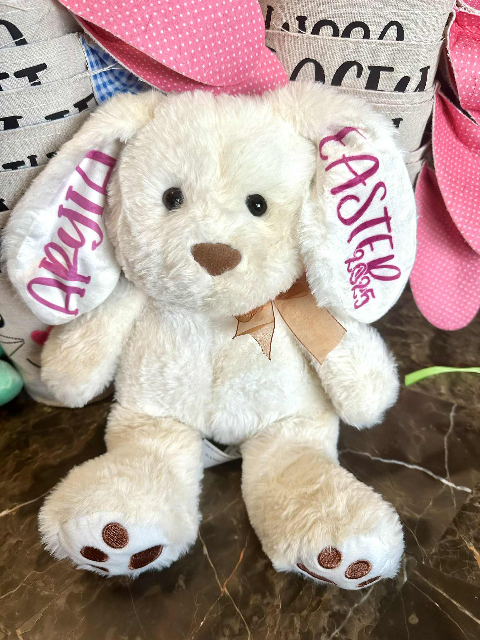 Plush bunny with pink ears and 'Easter Blesses' tag on a marble surface