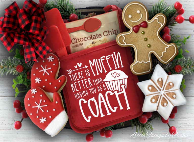 Red cookie press with Christmas-themed cookies and decorations on a wooden surface.