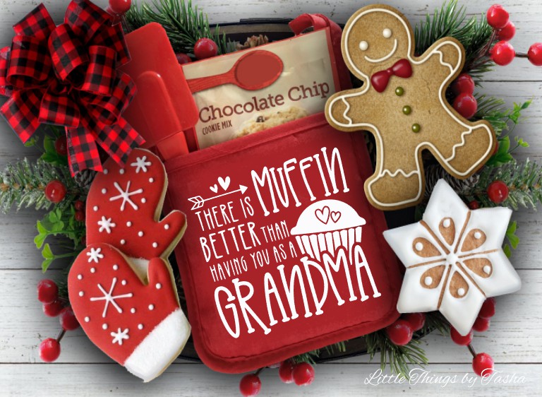 Red cookie press with gingerbread-themed cookies and Christmas decorations on a wooden surface.