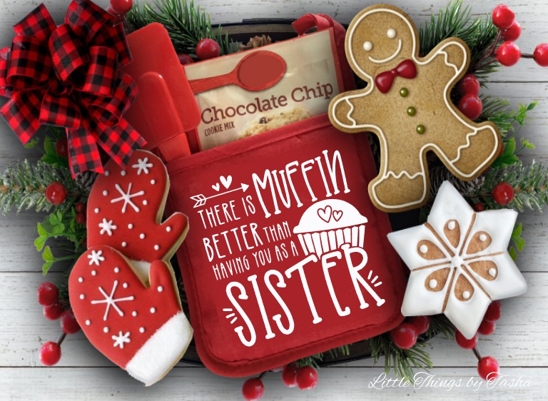 Red cookie press with gingerbread-themed cookies and Christmas decorations on a wooden surface.